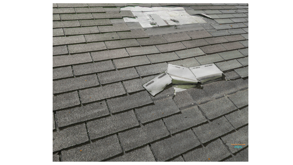 Close-up of a damaged shingle roof after a hurricane.