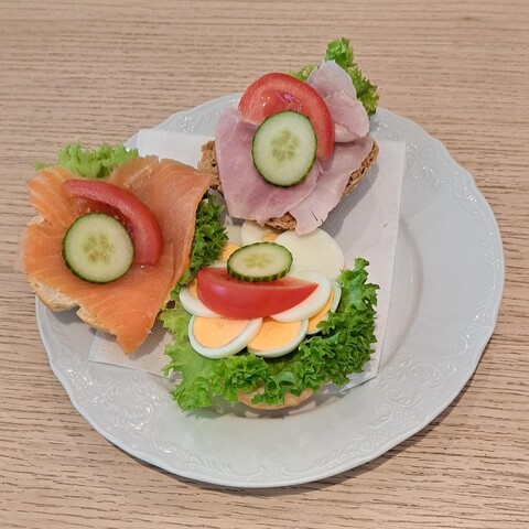 Belegtes Brötchen mit Ei, Schinken und geräuchertem Lachs