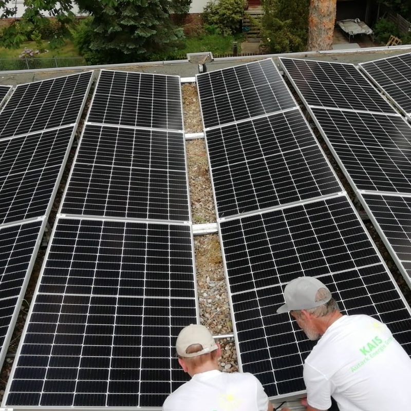Photovoltaikanlage mit zwei Technikern bei der Montage